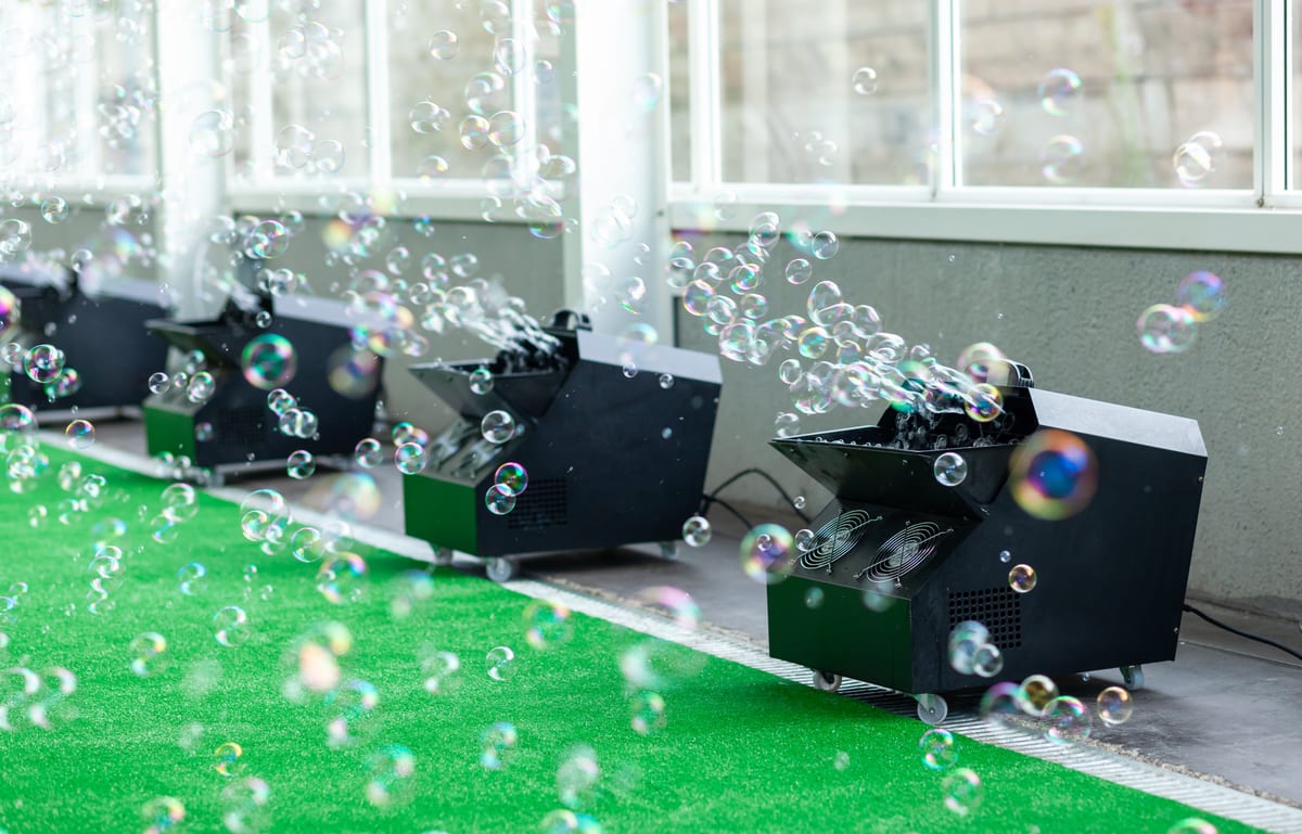 Bubble Machine hire — bubbles float from machines on green surface | Panda Party Hire Hire bubble machine — bubbles float from machines on green surface for parties and events in Johannesburg, Sandton and Randburg