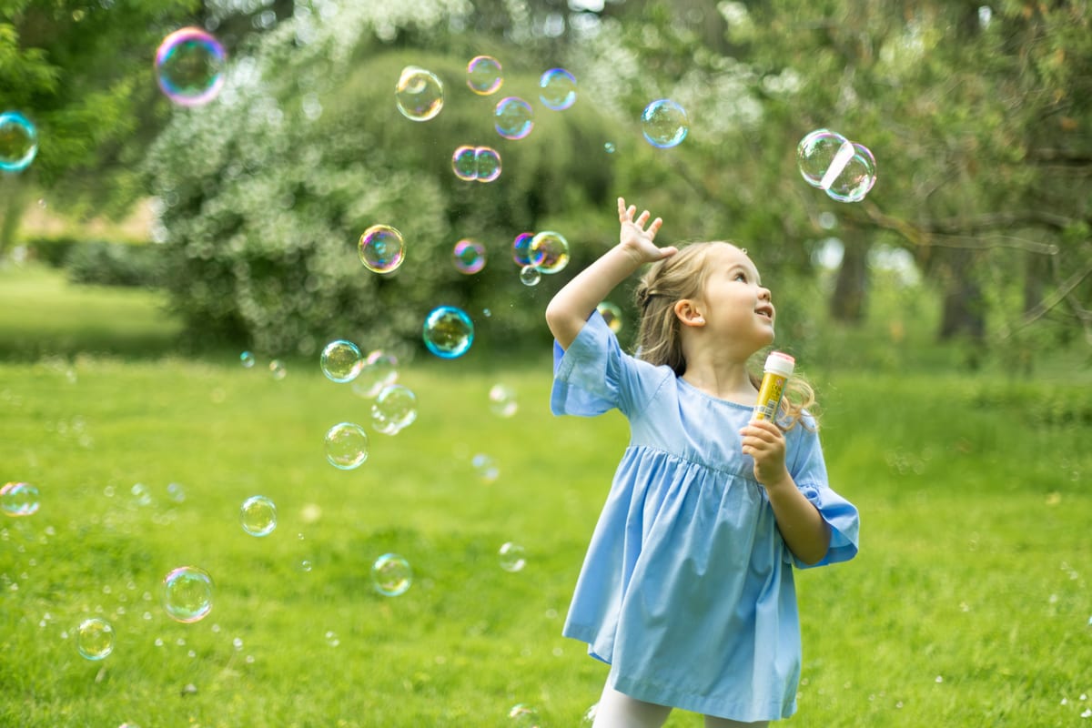 Bubble Machine hire — young girl playing with bubbles in vibrant park se | Panda Party Hire Hire bubble machine — young girl playing with bubbles in vibrant park se for parties and events in Johannesburg, Sandton and Randburg