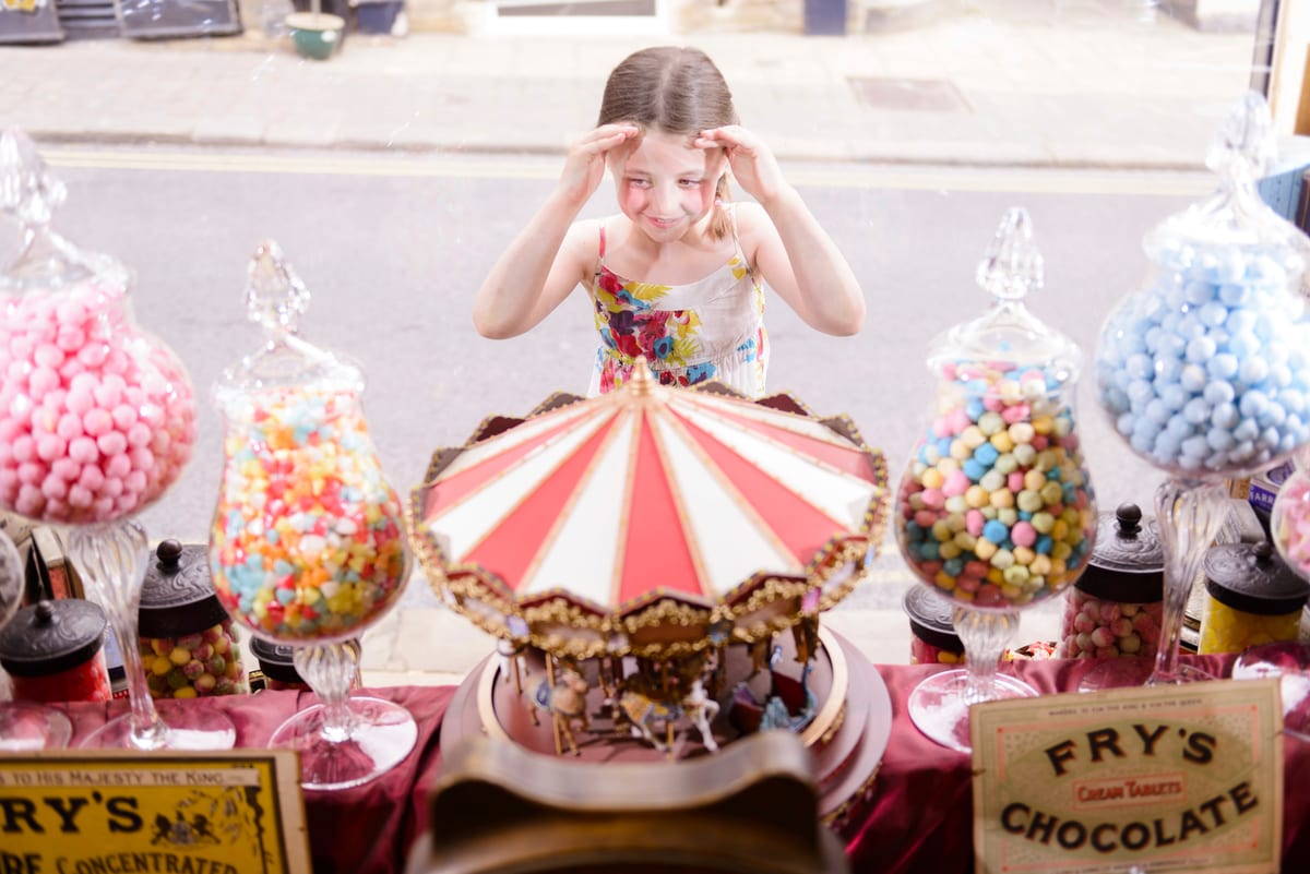 Candy Cart hire — girl looking through window of sweet shop | Panda Party Hire Hire candy cart — girl looking through window of sweet shop for parties and events in Johannesburg, Sandton and Randburg