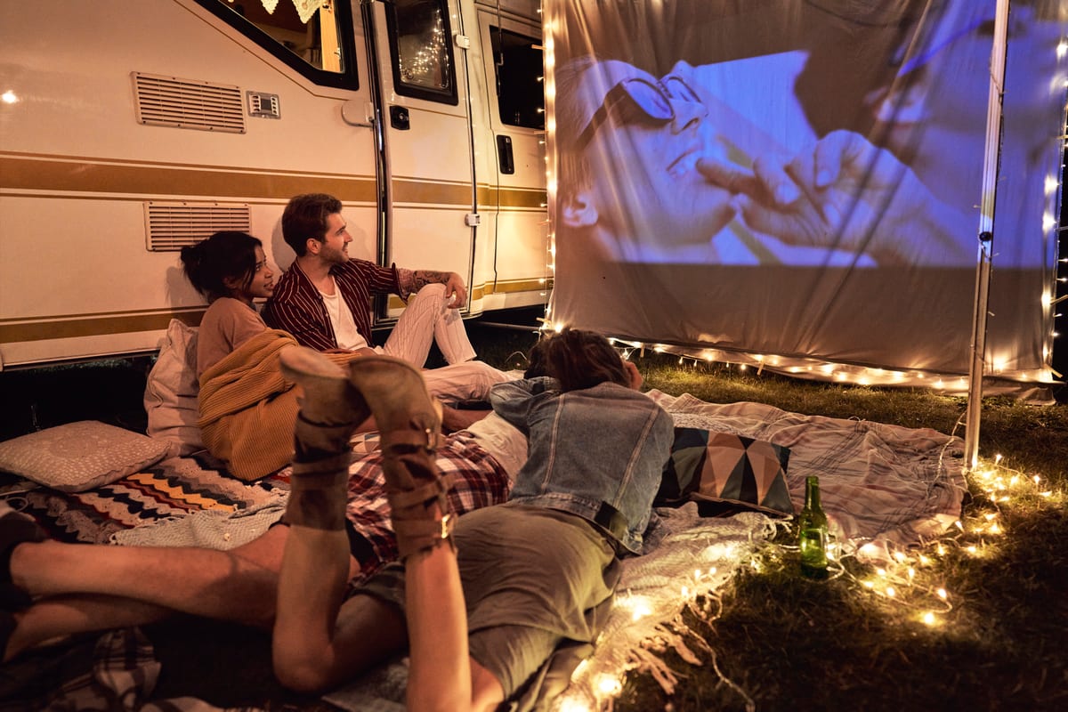 Outdoor Cinema hire — friends watching movie outside by a motorhome | Panda Party Hire Hire outdoor cinema — friends watching movie outside by a motorhome for parties and events in Johannesburg, Sandton and Randburg