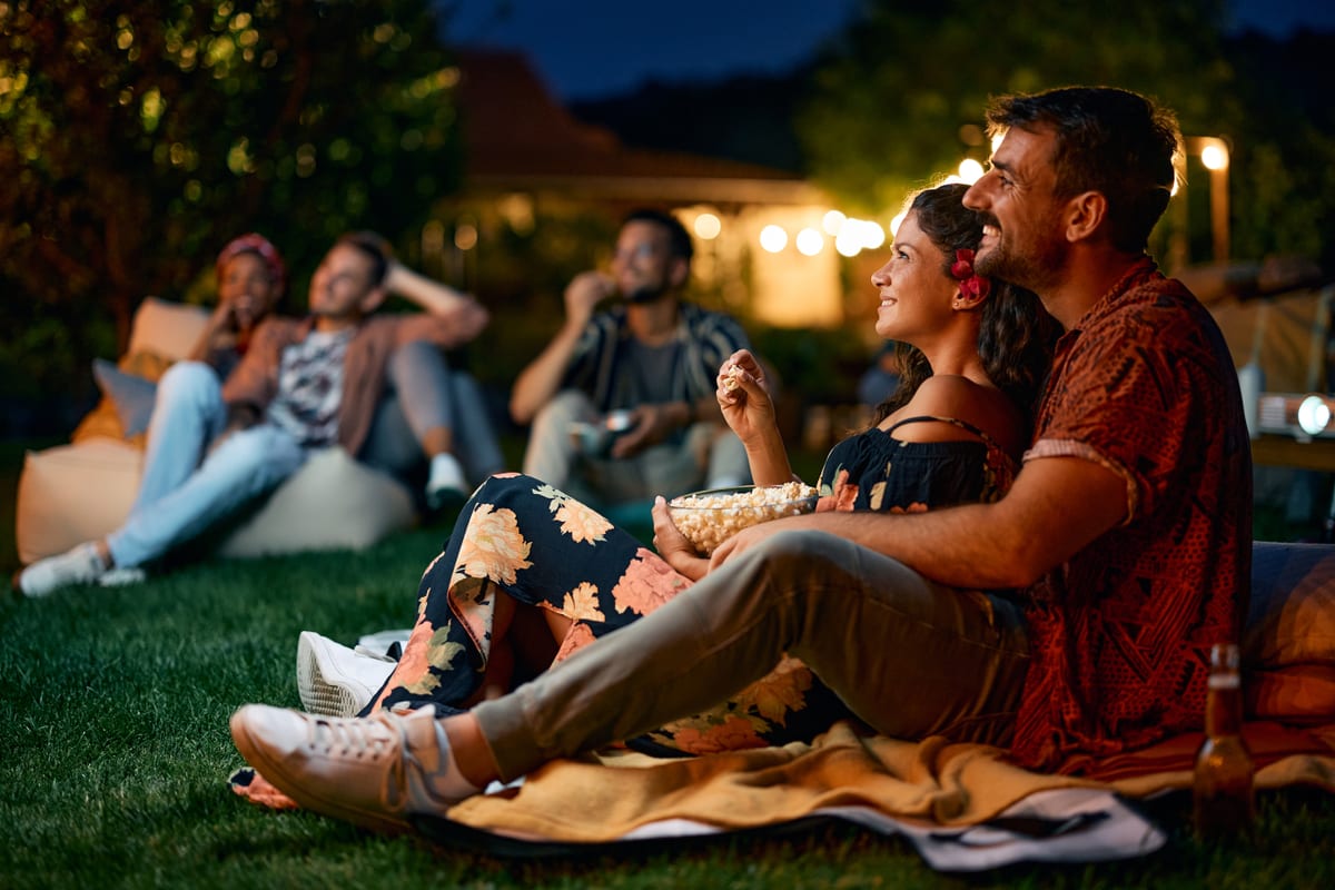 Outdoor Cinema hire — happy couple watching a movie in the yard | Panda Party Hire Hire outdoor cinema — happy couple watching a movie in the yard for parties and events in Johannesburg, Sandton and Randburg