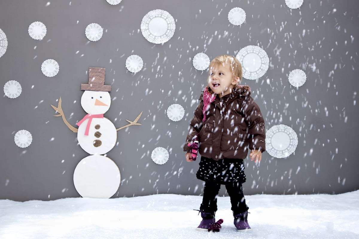 Snow Machine hire — toddler in winter enjoying snow near snowman decor | Panda Party Hire Hire snow machine — toddler in winter enjoying snow near snowman decor for parties and events in Johannesburg, Sandton and Randburg